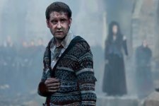 Neville Longbottom, played by Matthew Lewis, injured in the battle at Hogwarts likely thanks in part to Bellatrix Lestrange, seen in the background. 37845 photo